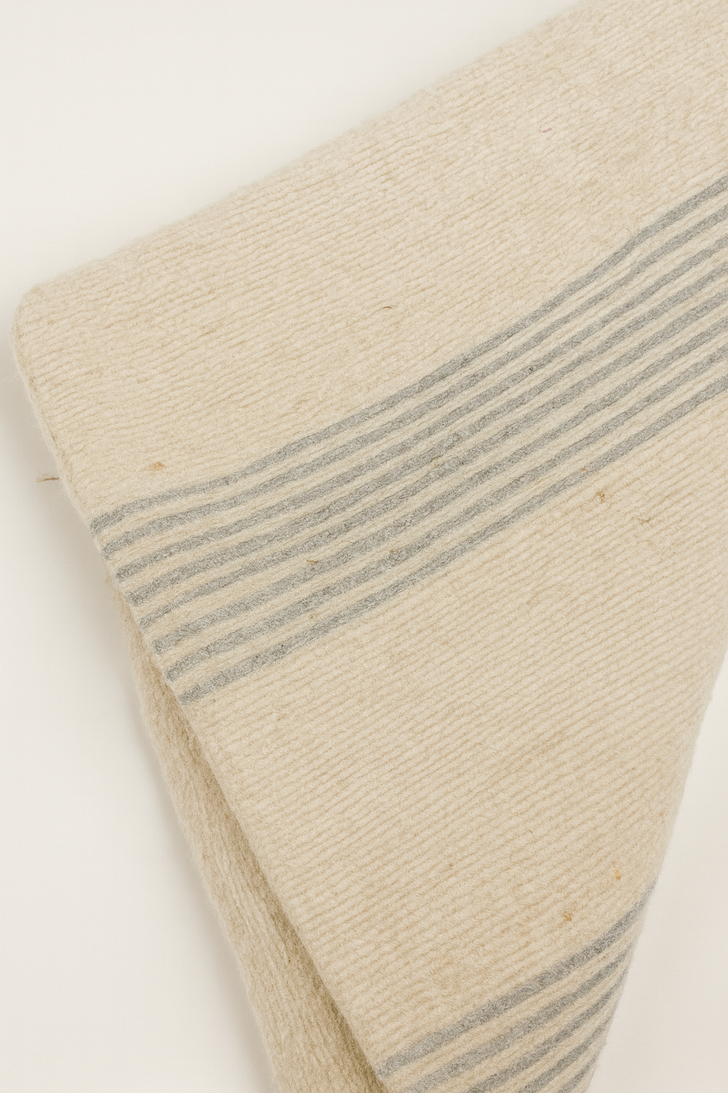 Coussin artisanal en pure laine brute à lignes claires